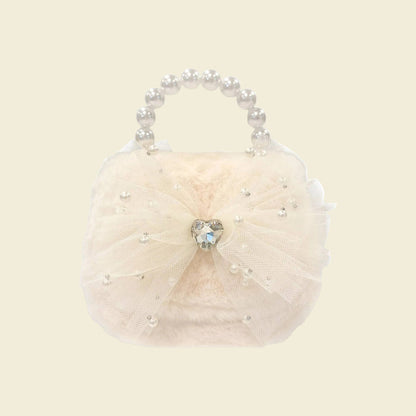 Cream-colored handbag with pearl handle and heart-shaped gem on a white background