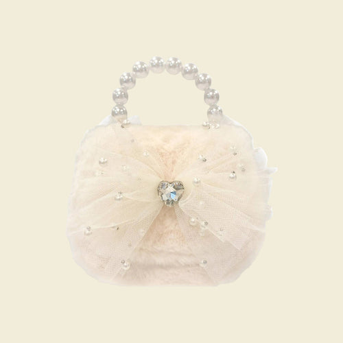 Cream-colored handbag with pearl handle and heart-shaped gem on a white background