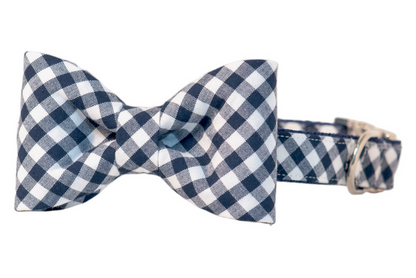 Stylish navy blue plaid dog collar with a matching bow tie attached at the front. The bow tie is symmetrically tied and made from the same cotton fabric as the collar, which also features reinforced stitching and metal hardware for leash attachment.