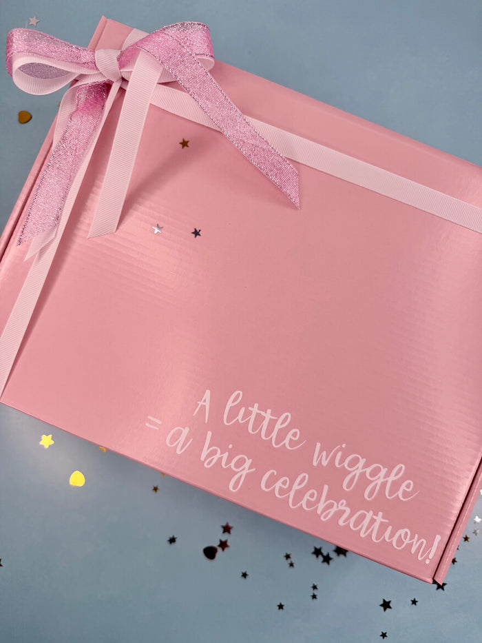 Pink gift box with a bow and text on a gray background