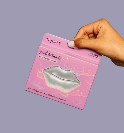 Hand holding a pink package of Spalife lip masks against a gray background
