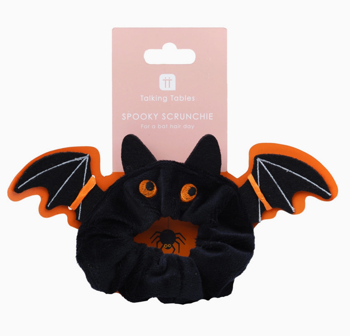 Black bat-shaped scrunchie with orange accents on a white background