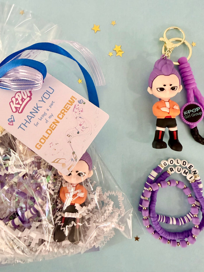 KPOP fan gift set with figurine, hair tie, and keychain on a light blue background