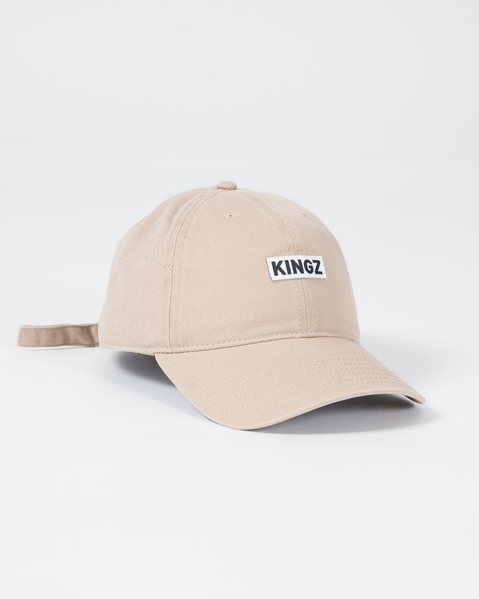 Kingz Slant Dad Hat - Khaki - Angled Front View Beige Hat KINGZ Text Front Panel Adjustable Strap Casual Style BJJ Training Apparel [color:Beige]