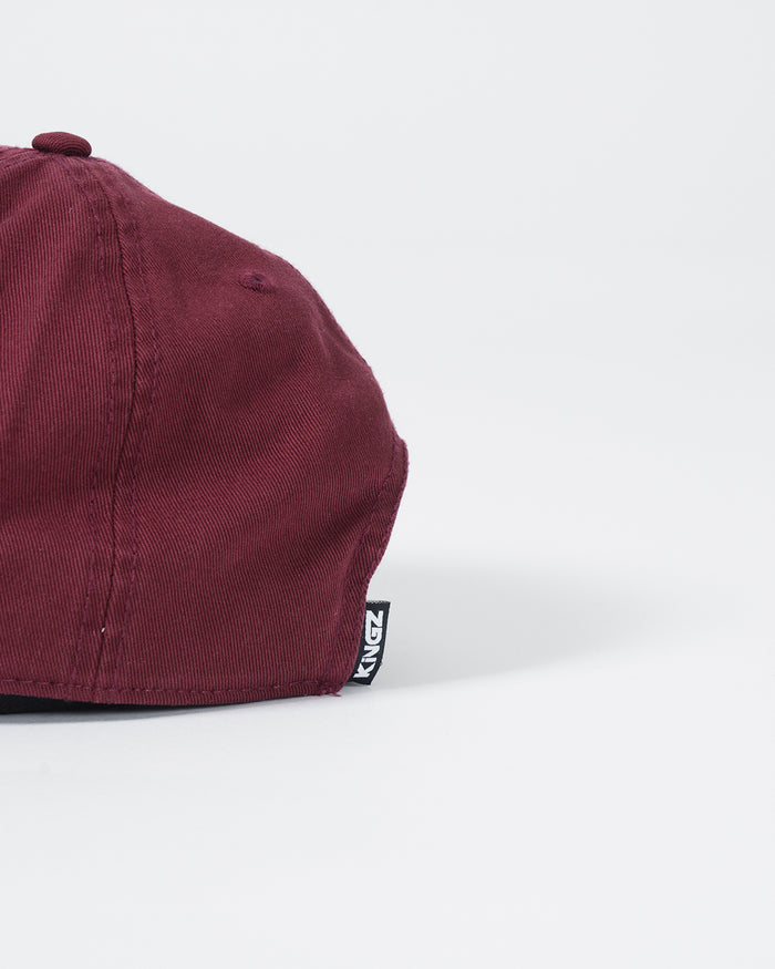 Kingz Slant Dad Hat Maroon - Close-Up Detail View Maroon Fabric Black KINGZ Tag Side Seam Casual Fit BJJ Training Apparel [color:Maroon]