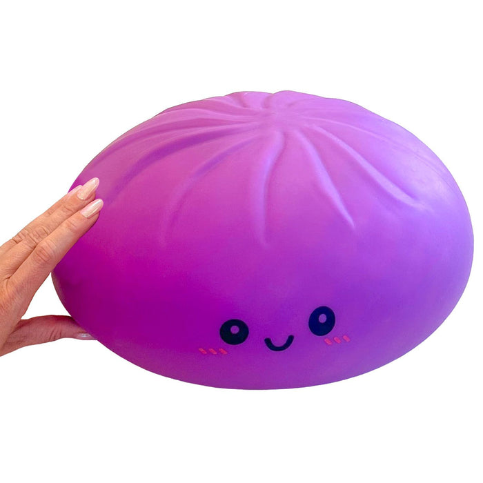 A purple squishy toy shaped like a dumpling with a cute face, held by a hand on the left against a white background.