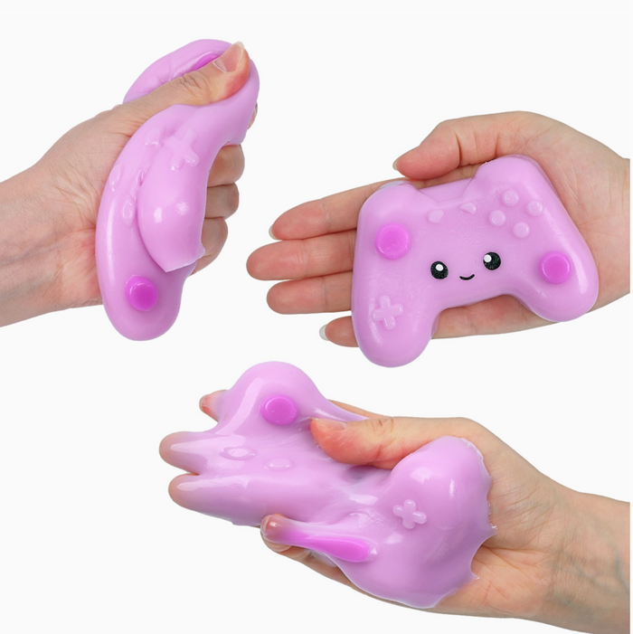 Pink squishy toy with a face being held and squeezed by hands on a white background