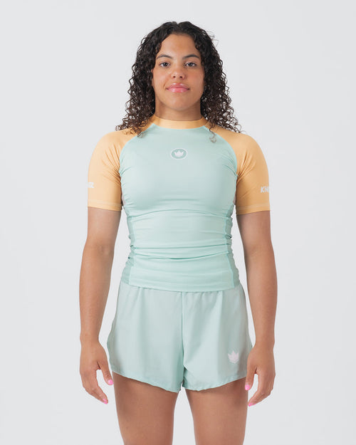 Kingz Terra Women's Rashguard Green Edition - Full Body Front View Female Athlete Short Sleeve Mint Light Green Body Yellow Peach Raglan Sleeves White Crown Logo Chest KINGZ White Text Matching Mint Green Hybrid Shorts BJJ No-Gi [color:Light Green]