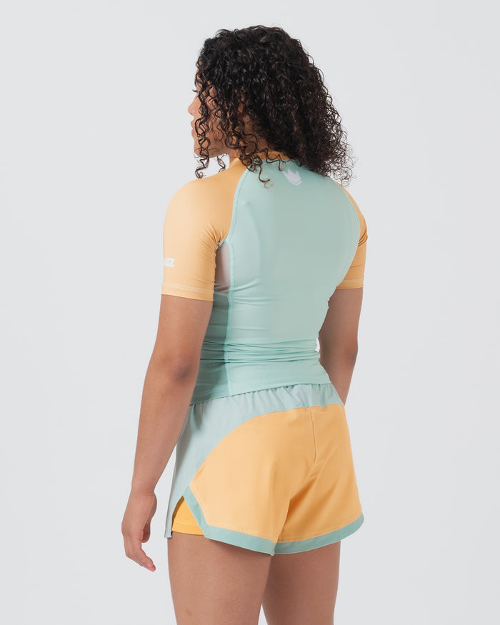 Kingz Terra Women's Rashguard Green Edition - Full Body Back View Female Athlete Short Sleeve Yellow Peach Raglan Sleeves Mint Green Back Panel White Crown Logo Upper Back Matching Hybrid Shorts Yellow Body Mint Trim Women's BJJ [color:Light Green]