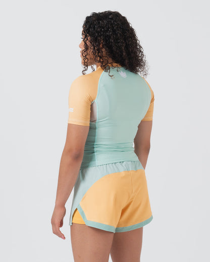 Kingz Terra Women's Rashguard Green Edition - Full Body Back View Female Athlete Short Sleeve Yellow Peach Raglan Sleeves Mint Green Back Panel White Crown Logo Upper Back Matching Hybrid Shorts Yellow Body Mint Trim Women's BJJ [color:Light Green]