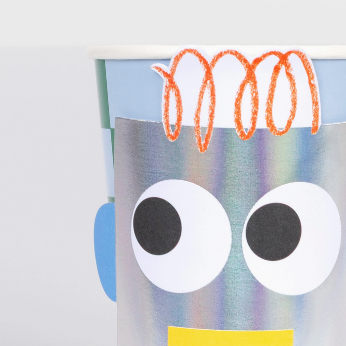Colorful robot craft with googly eyes and orange hair on a white background